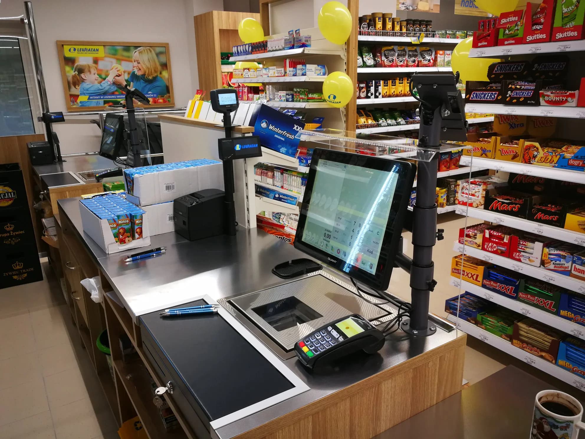 Stanowisko kasowe w sklepie: monitor dotykowy POS, wyświetlacz dla klienta, waga, drukarka fiskalna i terminal płatniczy